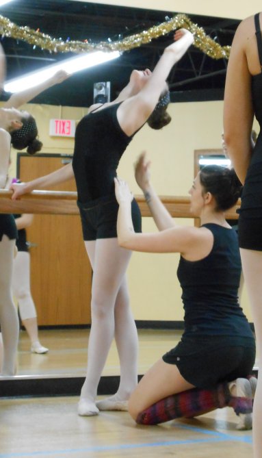 Miss Amy works with a student at the barre.
