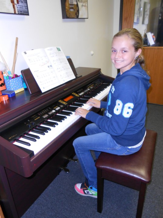 AMA music student Reilly sits at the piano.