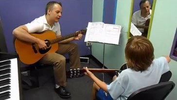 One of AMA's excellent guitar instructors teaches a student.