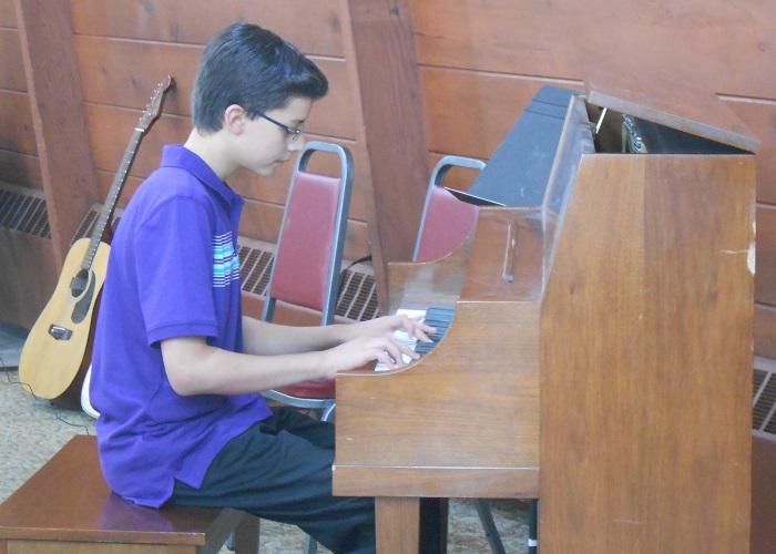 AMA student Mike plays the piano during a music recital in Des Plaines