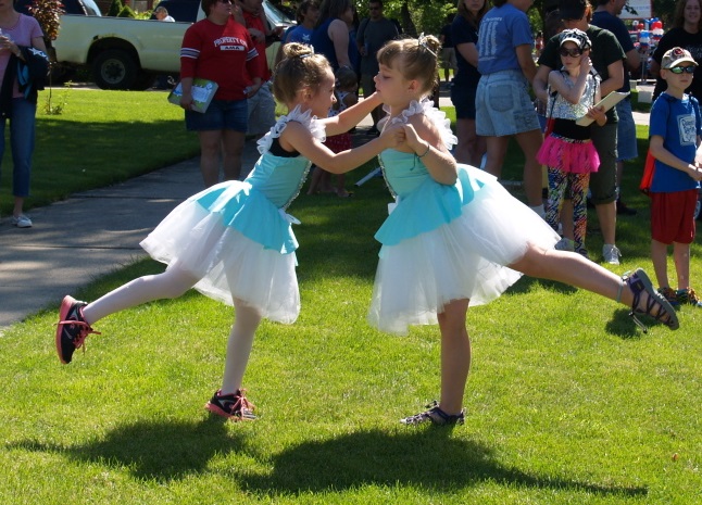 Two AMA friends dance and play before the parade