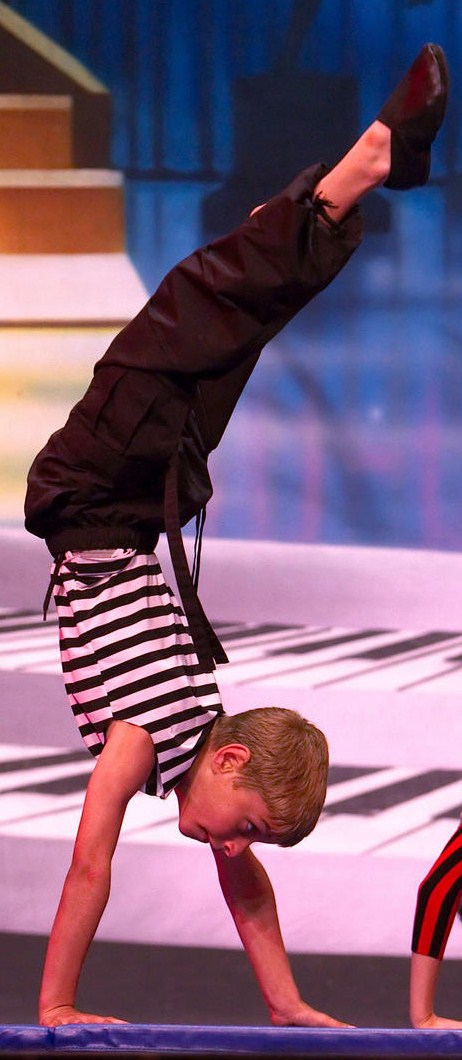 AMA student does handstand during a performance