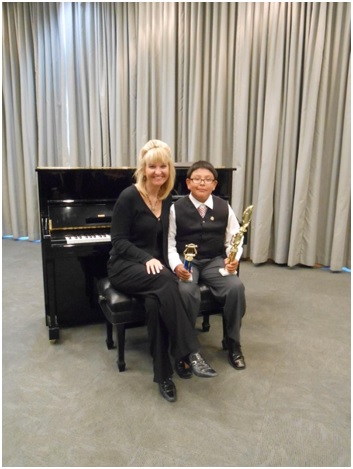 Ann Marie sits at the piano with a student