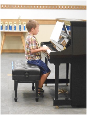 You music student plays the piano at the Spring Recital